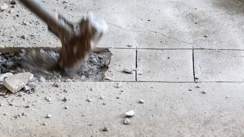 Sledgehammer demolishing a section of a concrete slab