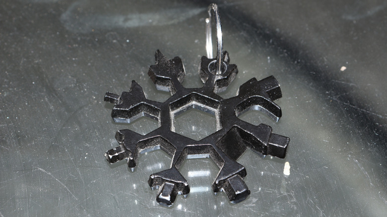 black snowflake tool sitting on a metal surface