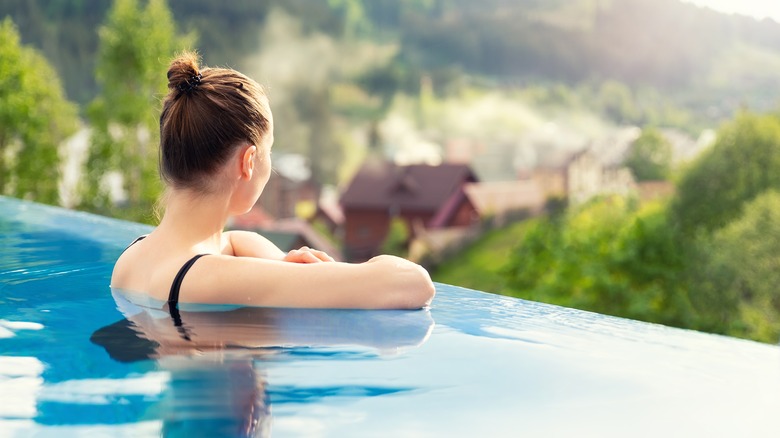 woman relaxing in infinity pool