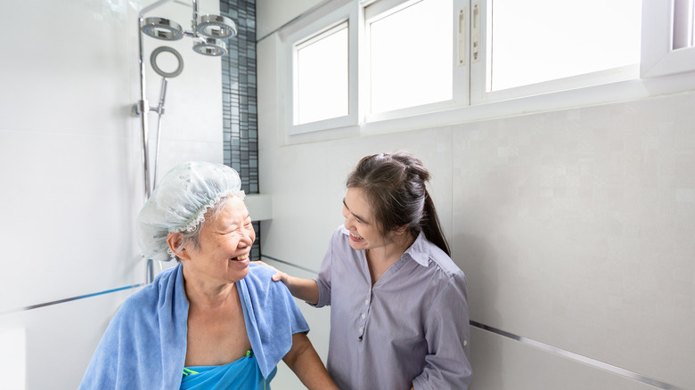 elderly woman helped in the shower 