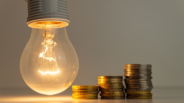 Light bulb next to coins