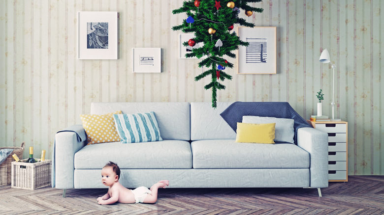 Baby beneath upside down christmas tree