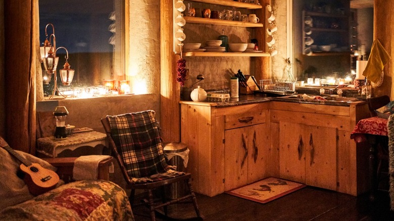 A tiny cabin kitchen lit by candlelight