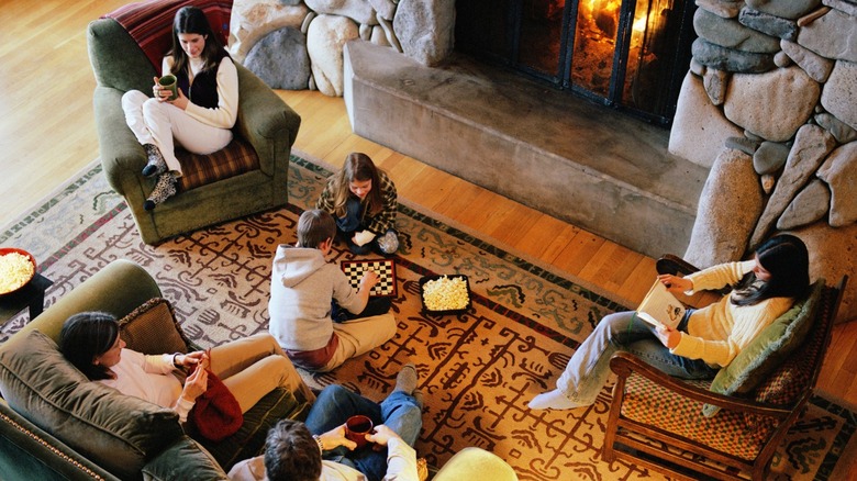 A family relaxes together near a stone fireplace