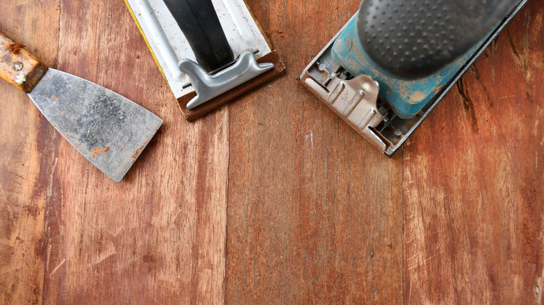 Sanding and carpentry tools on wood surface