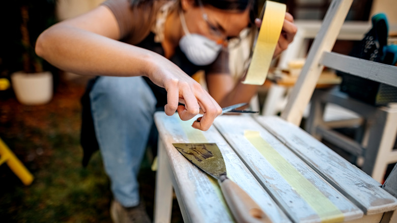 Person refinishing wooden chair