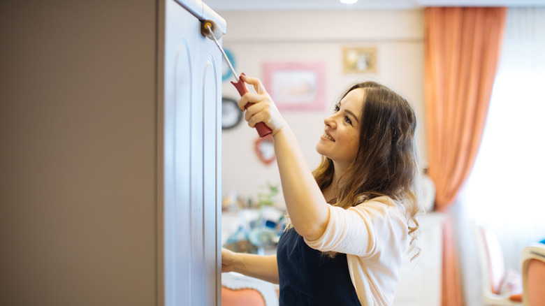 woman painting cabinet