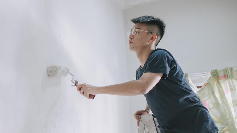 man painting room wall