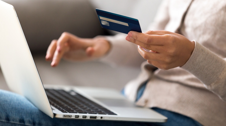 Hand with credit card and laptop