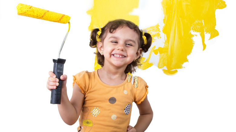 Little girl holding paint roller