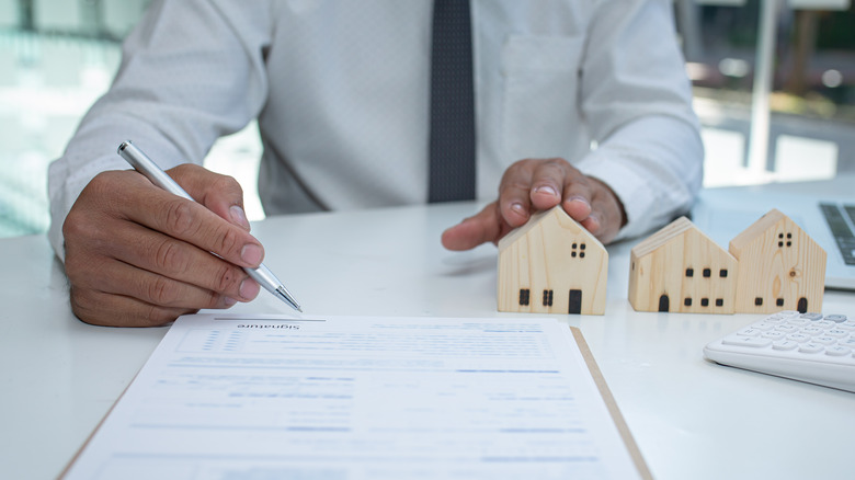 Man Signing Home Insurance Contract