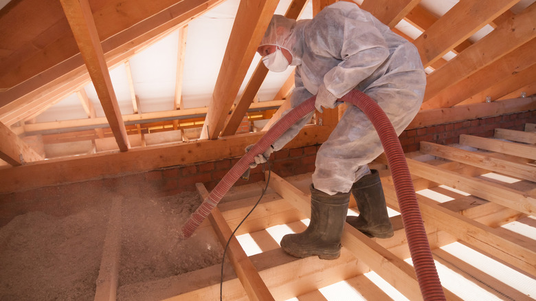 Man spraying ecowool in attic