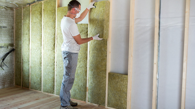 Man installing wool insulation