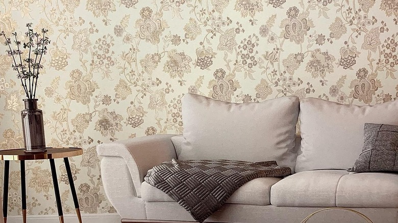 A couch sits in a modern living room in front of a wall papered with Jacquard fabric