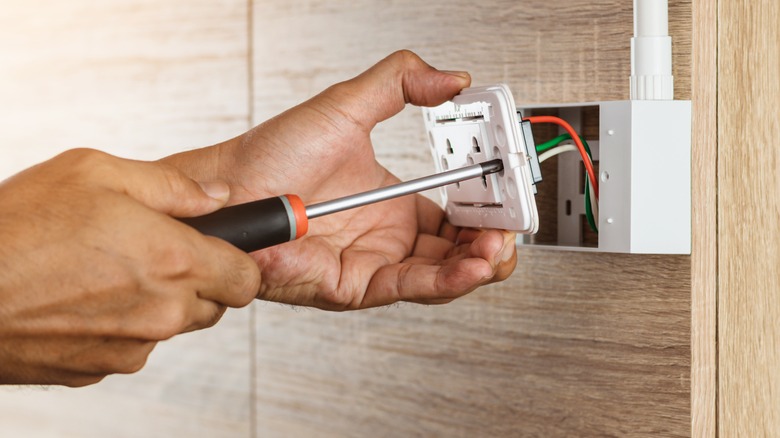 Person installing electrical outlet