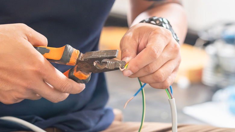 Man using pliers to cut and twist wire