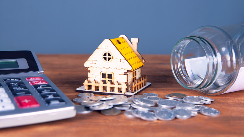 Coins, calculator, tin and house