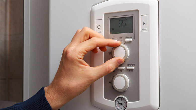 Person adjusting thermostat