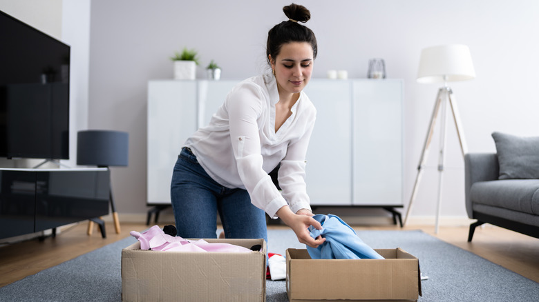 woman decluttering clothes in boxes