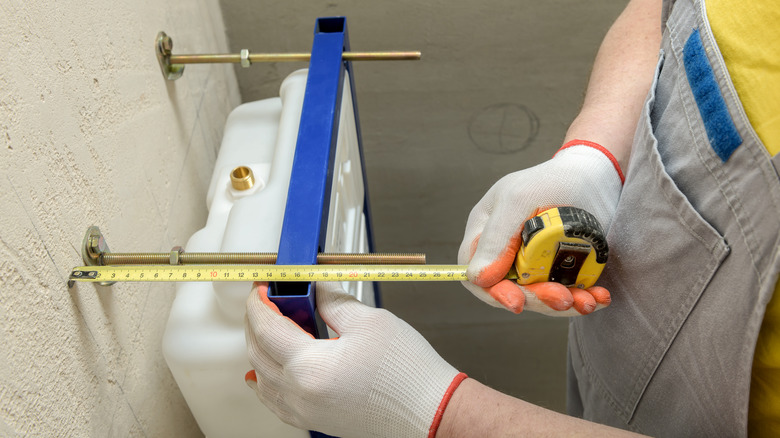 Person measuring toilet space