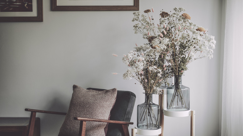 chair and dried flowers near a window