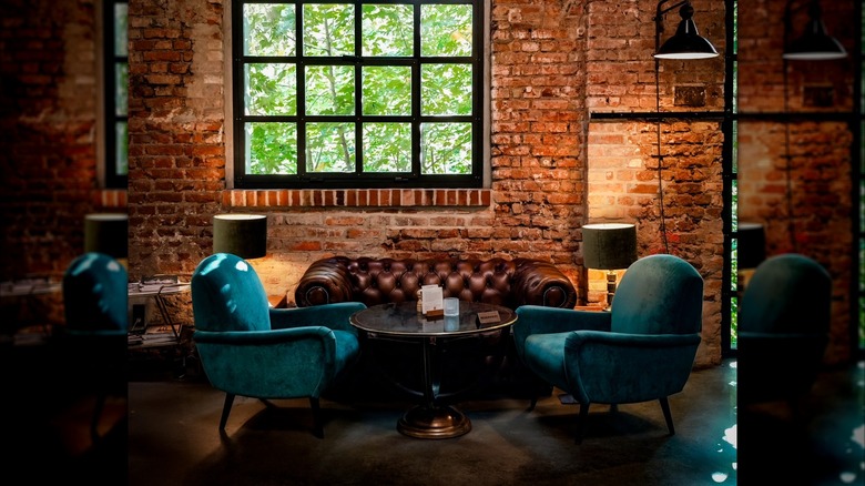 Two armchairs flank a leather Chesterfield sofa