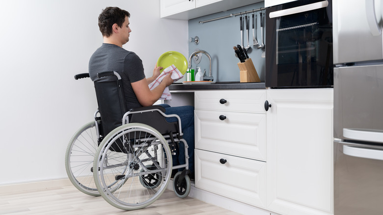 Man in wheelchair washing dishes