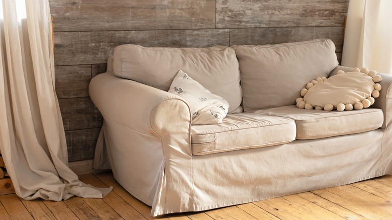 neutral couch with wooden wall