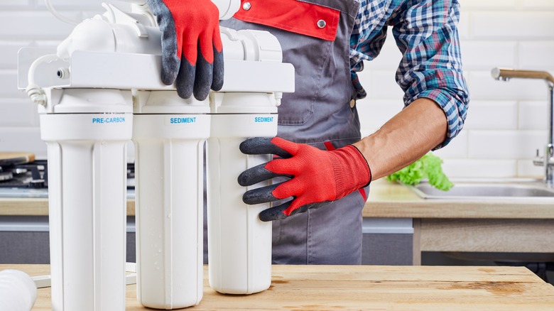 Repairman installing water filtration system