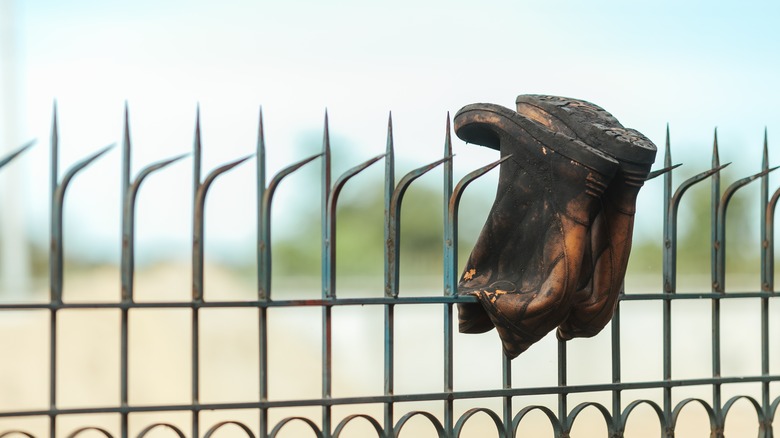 Boots hanging on fence