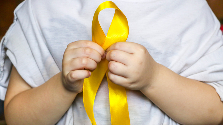 Child holding gold ribbon