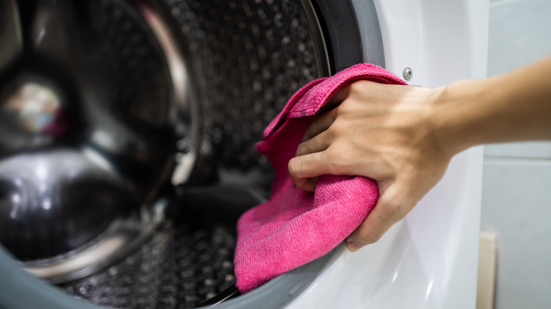 Person cleaning washing machine barrel