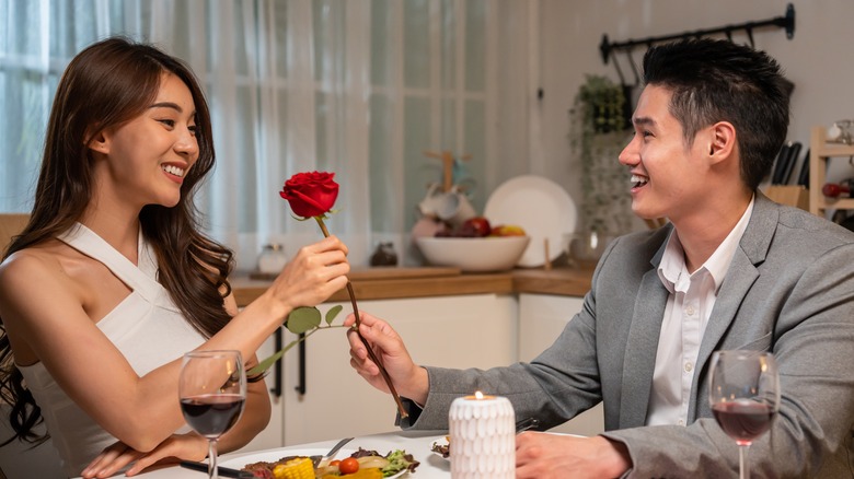 Man giving woman red rose