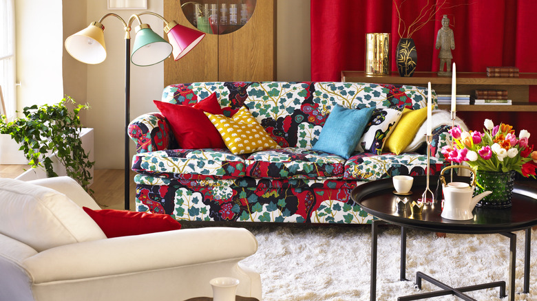 Maximalist liiving room with colorful cushions and print sofa