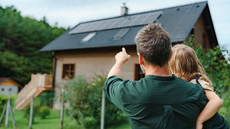 Father showing daughter solar panels on their home