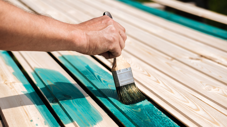 person painting a deck