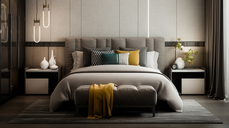 Modern gray bedroom and bed with a gray rug underneath it.