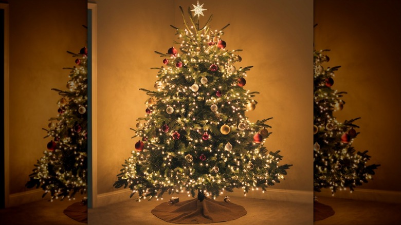 A Christmas tree is decorated with a beige skirt