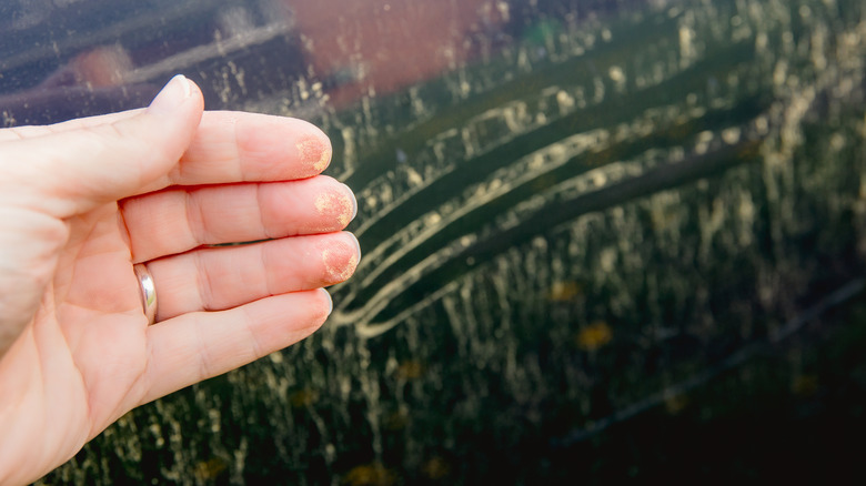 Person wiping yellow pollen