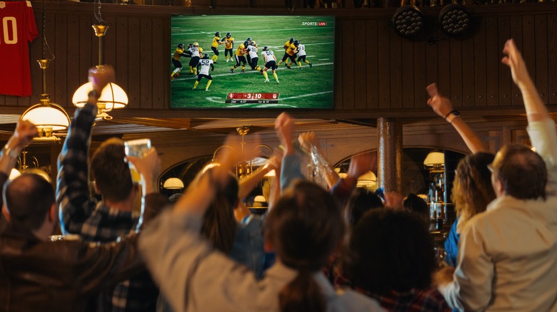 Group of people cheering at tv