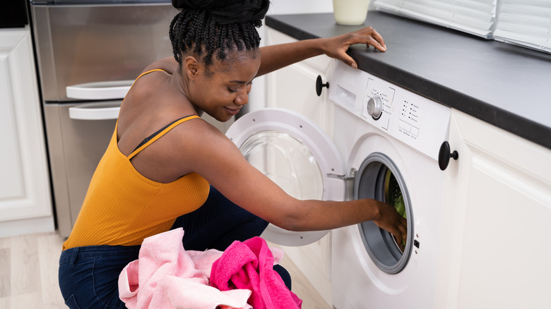 Woman pulls clothes from dryer