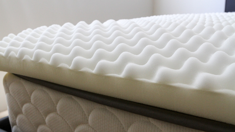 White egg crate mattress topper on bed