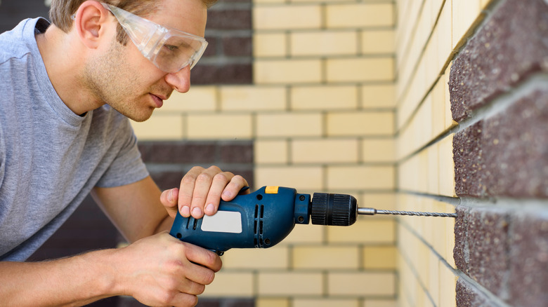 man drilling into brick