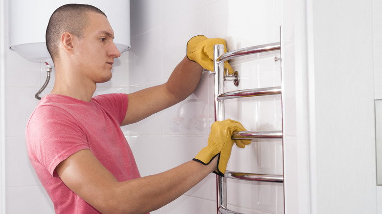 Person installing heated towel bar