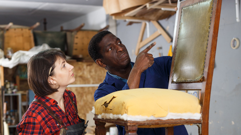 People inspecting a vintage chair