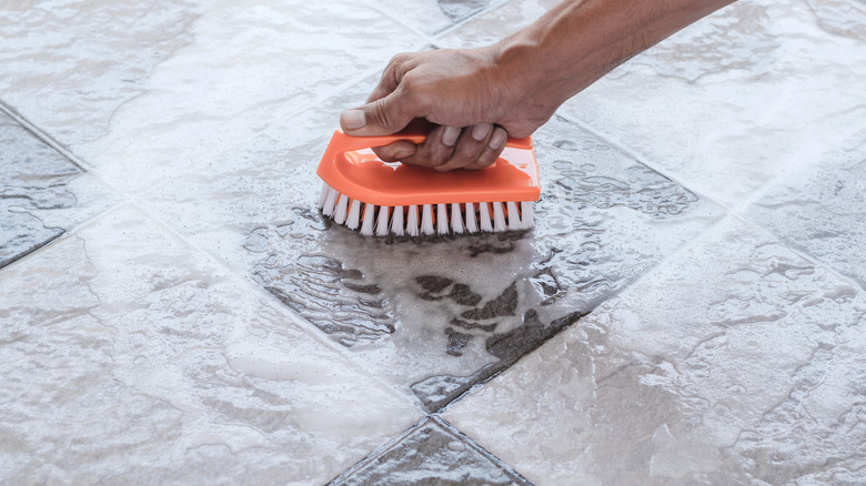 person washing tile floors