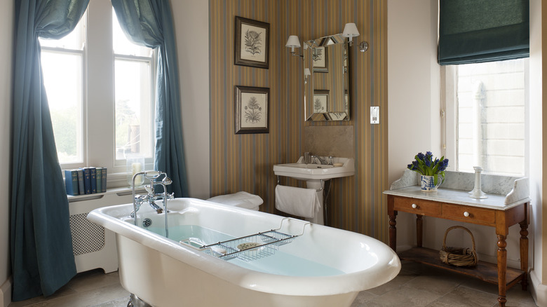 Stylish bathroom with claw-foot bathtub filled with water