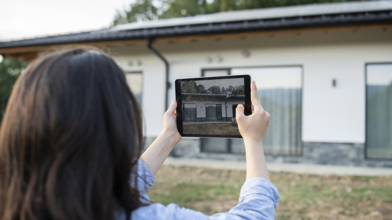 Woman taking photos of her home property damage for insurance purposes