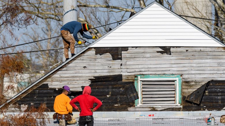 Contractors fixing a home that has been damaged by a winter storm