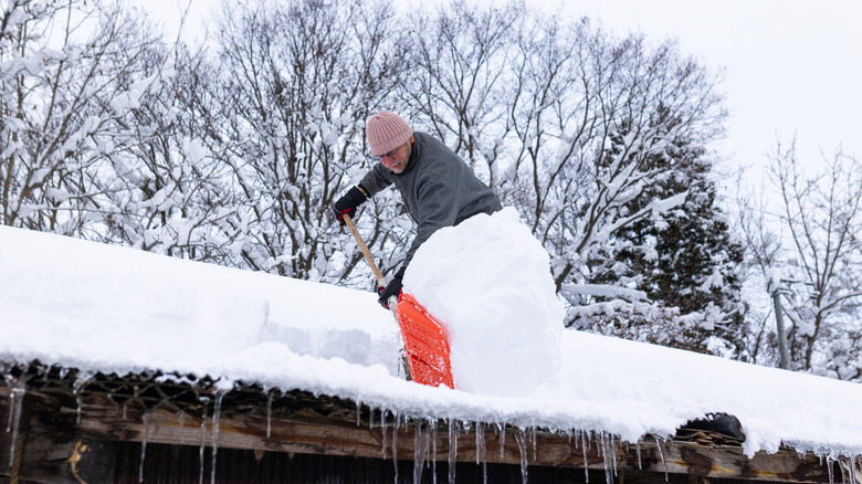 Man shoveling snow off his roof